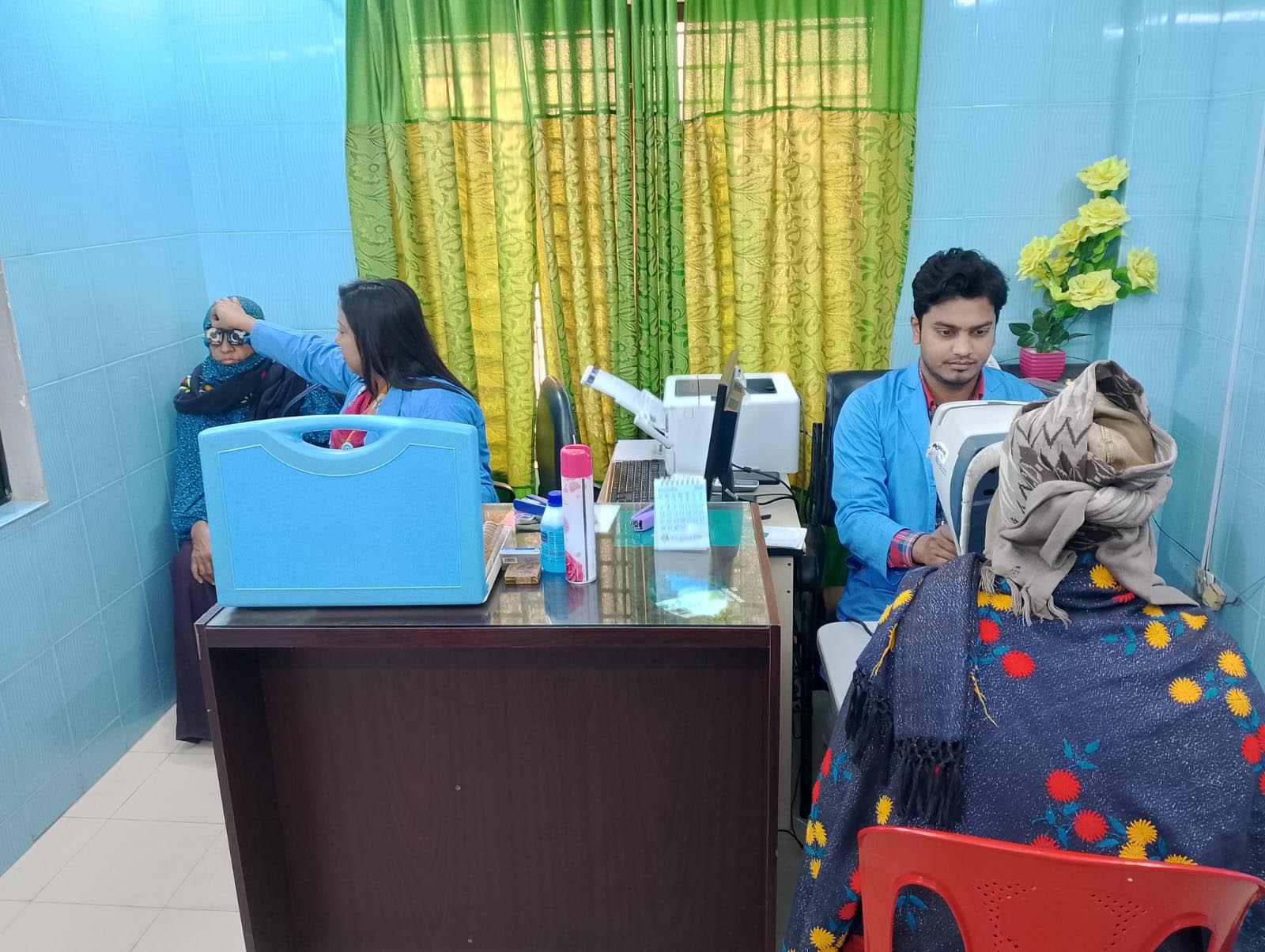 রোগীদের চোখের দৃষ্টি পরীক্ষা ও চশমা ফিটিং করা হচ্ছে