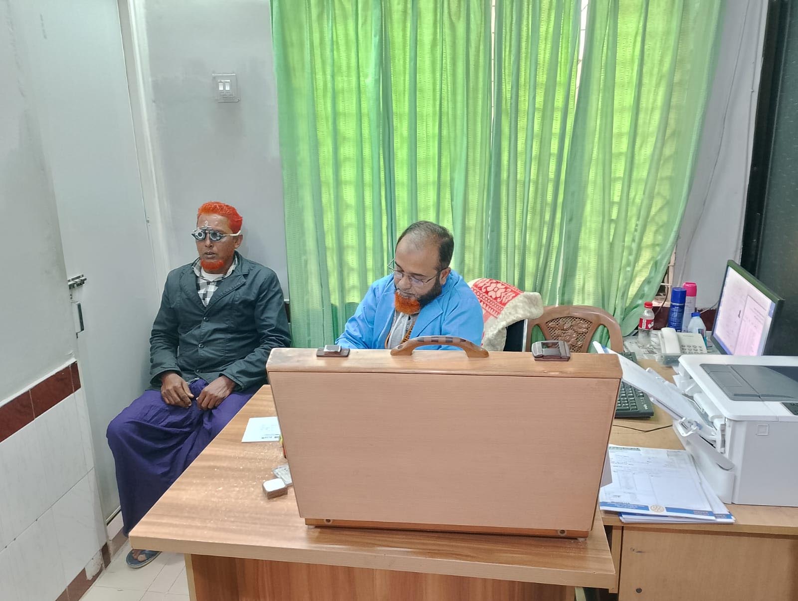 রোগীদের চোখের দৃষ্টি পরীক্ষা ও চশমা ফিটিং করা হচ্ছে